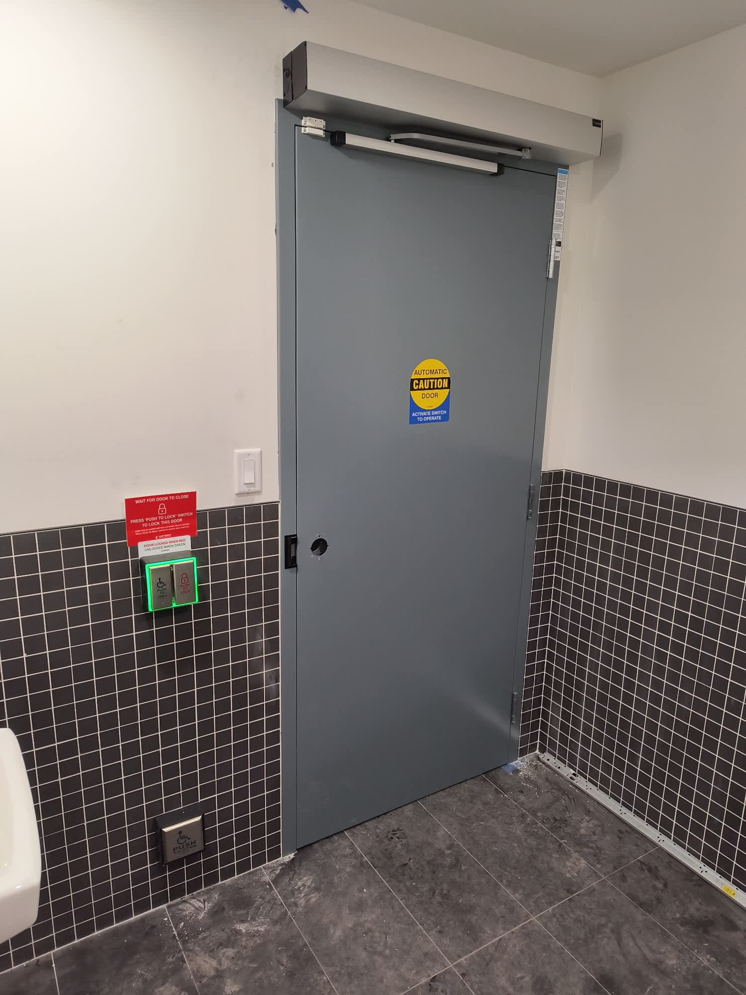 Barrier-free washroom door with an automatic operator, electric strike and push buttons